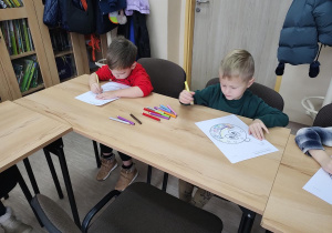 Dzieci wykonują świąteczną bombkę