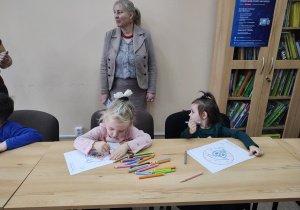 Dzieci wykonują świąteczną bombkę