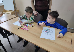 Dzieci wykonują świąteczną bombkę