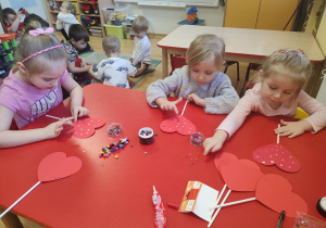 Dzieci wykonują walentynkowe serca