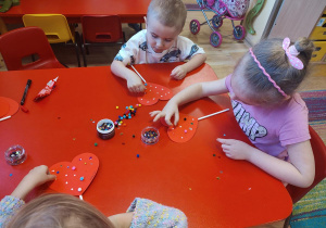 Dzieci wykonują walentynkowe serca