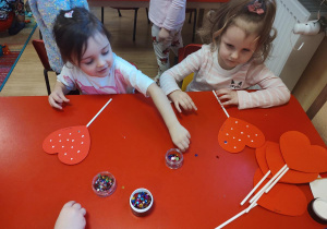 Dzieci wykonują walentynkowe serca