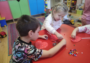 Dzieci wykonują walentynkowe serca