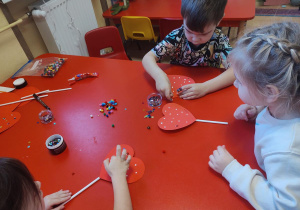 Dzieci wykonują walentynkowe serca