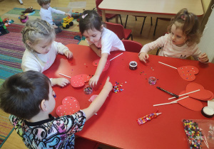 Dzieci wykonują walentynkowe serca