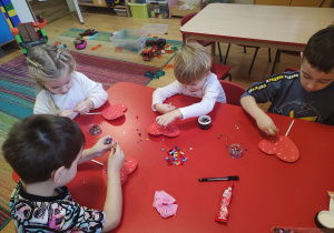 Dzieci wykonują walentynkowe serca