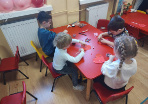 Dzieci wykonują walentynkowe serca