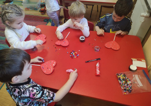 Dzieci wykonują walentynkowe serca