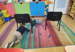 Dzieci wykonują slalom między krzesełkami