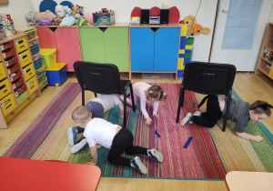 Dzieci wykonują slalom między krzesełkami