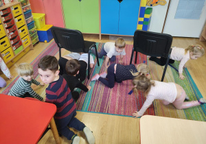 Dzieci wykonują slalom między krzesełkami