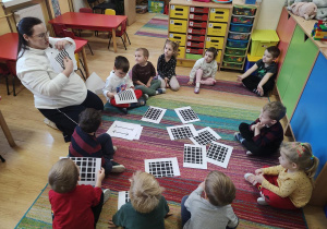 Dzieci oglądają karty przedstawiające złudzenia optyczne