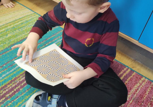 Dzieci oglądają karty przedstawiające złudzenia optyczne