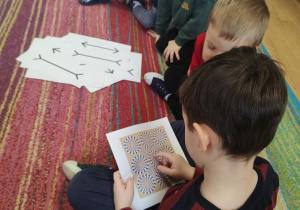 Dzieci oglądają karty przedstawiające złudzenia optyczne