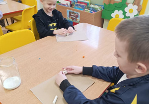 Dzieci lepią bałwany z plasteliny.