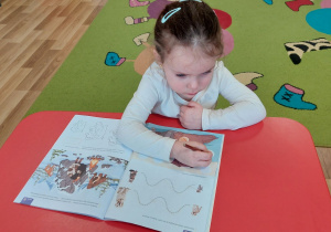 Maja uzupełnia karty pracy.