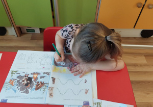 Pola R. uzupełnia karty pracy.