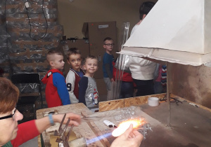 Dzieci oglądają ogrzewanie szklanej rurki.