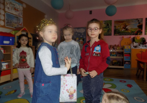 Gabrysia częstuje Lenkę urodzinowym cukierkiem.