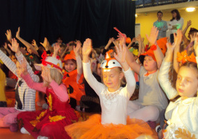 Dzieci podnoszą ręce do góry i tańczą