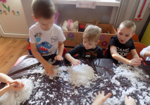 Dzieci w czasie zabawy sztucznym śniegiem.