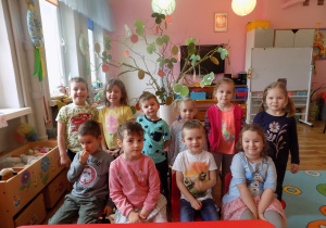 Dzieci prezentują wspólnie wykonane wiosenne drzewko