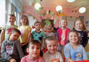 Dzieci prezentują wspólnie wykonane wiosenne drzewko