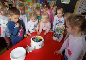 Dzieci podziwiają tort urodzinowy kolegów