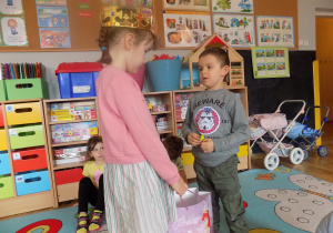 Lenka częstuje Piotrka urodzinowym cukierkiem.