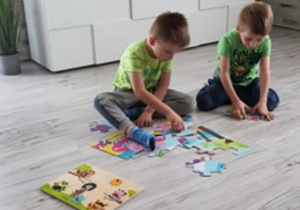 Kacper i Oskar układają puzzle