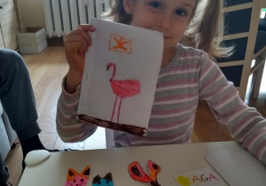 Natalka pokazuje wykonaną książeczkę o flamingach. Brawo!!