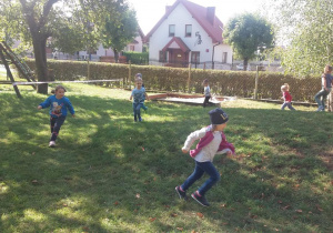 Marysia, Nadia, Tymek, Filip, Mace, Nikola i Róża biegają w ogrodzie.