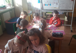 Dzieci wyklejaja literę I.