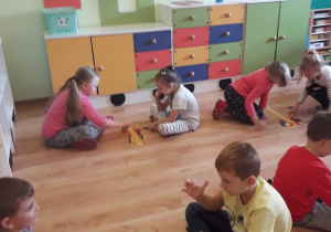 Dzieci układają kompozycje wzdłuż linii symetrii.