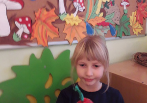 Julia pokazuje wykonane jabłko z masy papierowej.