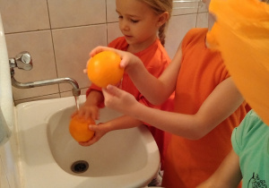 dziewczynki myją pomarańcze