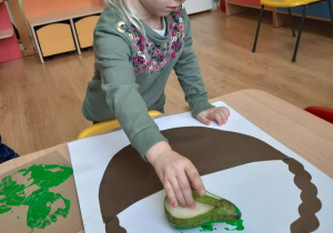 Nikola wykonuje pracę "Jesienny kosz".