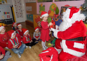 Gabrysia odbiera prezent od Mikołaja.