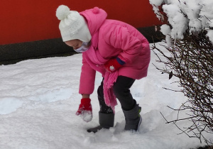 Natalka lepi kulę sniegową.
