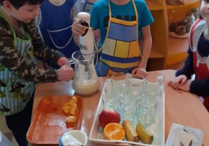 Kacper blenduje jogurt z owocami.