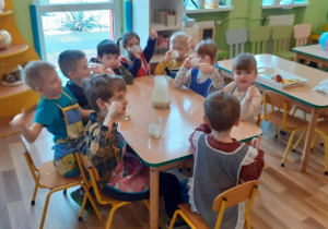 Dzieci piją pyszny jogurt owocowy.