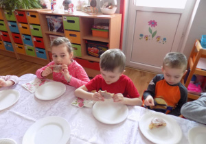 Lena, Marcel i Filip smakują pączki.