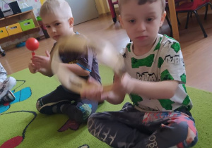 Dzieci tworzą muzykę za pomocą instrumentów - tamburyna i marakasów