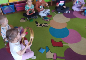 Dzieci tworzą muzykę za pomocą instrumentów - tamburyna i marakasów